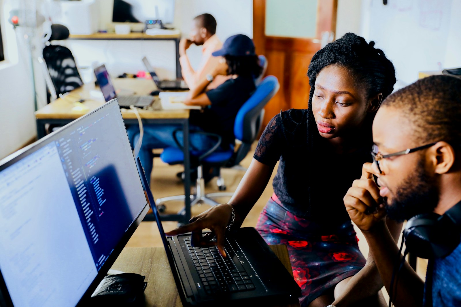 Instructor and learners working around laptops during a technical training session